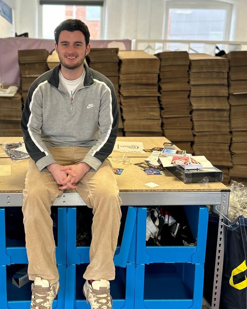 Rory sitting on a packing bench in the new office